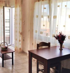 a dining room with a table and chairs and windows at Nice & Quiet Apartment in Best Area in Alexandroupoli