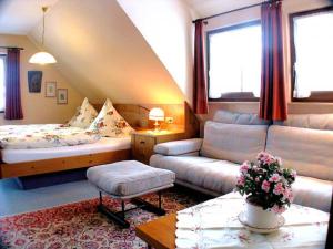 - un salon avec un canapé et un lit dans l'établissement Landhaus-Seiler, à Freudenstadt
