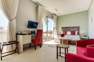 een slaapkamer met een bed en een bureau met een televisie bij The One 8 Hotel in Kaapstad