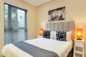 a bedroom with a large bed with two lamps at The One 8 Hotel in Green Point - Solar Power in Cape Town