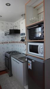 a kitchen with a microwave and a stove at Casa Pali in Puerto Montt