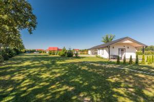 a large yard with a small white house at Uzenabow in Wicie