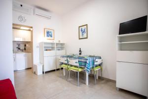 a kitchen and dining room with a table and chairs at Sunset Holiday House in Torre Lapillo