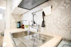 a kitchen with a sink and a counter top at Sunset Holiday House in Torre Lapillo