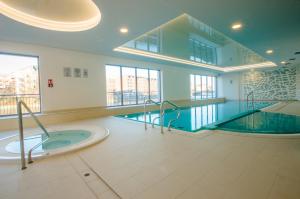 uma piscina com uma banheira de hidromassagem num edifício em Grand Apartments - Apartments SPA Waterlane Island em Gdansk