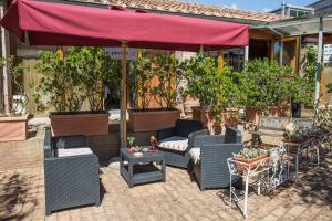 a patio with chairs and a couch and an umbrella at Hotel Il Giardino in Siena
