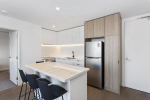 a kitchen with a counter and a refrigerator at Ilixir Apartments by Ready Set Host in Cheltenham