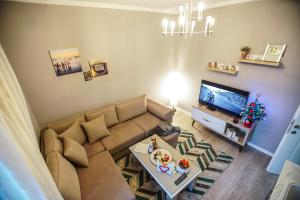 a living room with a couch and a television at Elite Apartments Korçë in Korçë