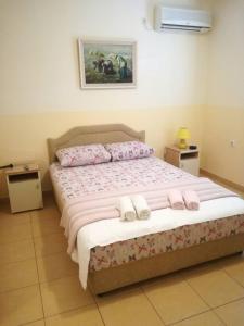 Un dormitorio con una cama con zapatillas. en Djukic apartments en Budva