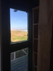 an open window with a view of a field at La Cañada Cabo Polonio in Cabo Polonio