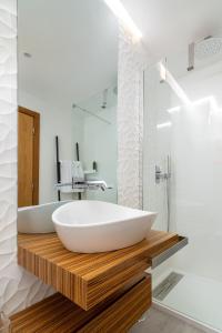 een badkamer met een groot wit bad op een houten aanrecht bij The Explorer's Home | Sunny. Central. Free Parking in Lissabon