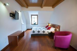 シュチルクにあるPensjonat Maria 2のベッドルーム(ベッド1台、紫色の椅子付)