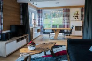 a living room with a table and a dining room at Ferienwohnung Zillertal Bacher in Schlitters