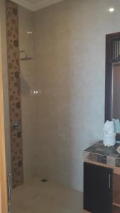 uma casa de banho com um chuveiro e um lavatório. em Asiana Lovina Hotel em Lovina