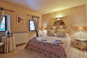 a bedroom with a large bed and two windows at Les Carmes and spa in Le Thor