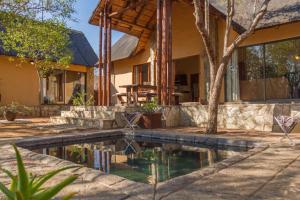 a house with a swimming pool in front of a house at Warthogs Rest in Hoedspruit