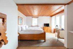 Schlafzimmer mit einem Bett mit Holzdecke in der Unterkunft Eden Hotel und Restaurant in Ilanz