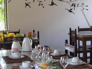 a dining room table with birds on the wall at Pousada Dos Girassois Prado in Prado