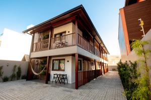 a building with a balcony on the side of it at Banzai Brava Suítes in Itajaí