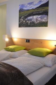2 Betten mit grünen Kissen in einem Zimmer in der Unterkunft Chasa Ravaischa in Samnaun
