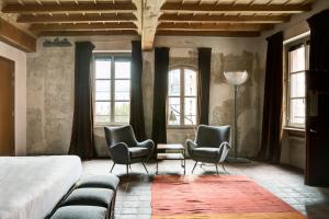 Schlafzimmer mit 2 Stühlen, einem Bett und Fenstern in der Unterkunft Casa del Pingone in Turin