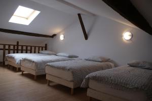 a bedroom with three beds and a skylight at Crezilles Hôtes in Crézilles