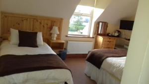 1 dormitorio con 2 camas y ventana en Ashfield B&B, en Kenmare