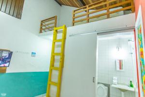 a room with a bunk bed and a bathroom with a ladder at Suítes Casa Maembippe in Ilhabela