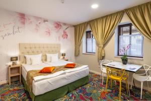a bedroom with a bed and a table and chairs at Blumenhaus Sibiu in Sibiu