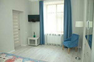 um quarto com uma cadeira azul e uma janela em вулиця Лемківська em Lviv