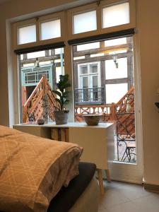 Studioapartment G16 - in exklusiver Innenstadtlage في بوتسدام: غرفة بسرير وشرفة مع نوافذ