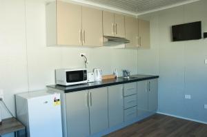 uma cozinha com um frigorífico branco e um micro-ondas em Bellhaven Park em Heatherbrae