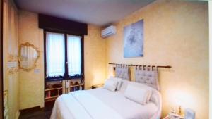 Bed & Breakfast A San Siro 75 في ميلانو: غرفة نوم بسرير ابيض كبير ونافذة