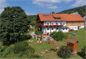 una gran casa blanca con un patio con un edificio en Pension Draxlerhof en Neuschönau