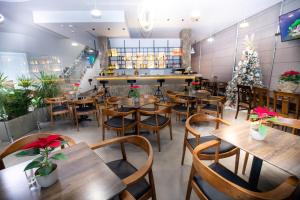 a restaurant with wooden tables and chairs and a christmas tree at Metro Hotel Tirana in Tirana