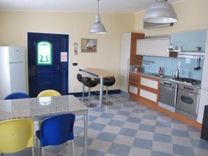 eine Küche mit einer blauen Tür sowie einem Tisch und Stühlen in der Unterkunft Azores Residence in Pesqueiro
