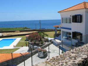 a house with a swimming pool next to the ocean at Azores Residence in Pesqueiro