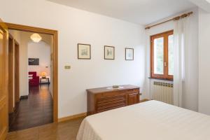 ein Schlafzimmer mit einem Bett und einem Tisch sowie einem Flur in der Unterkunft Il Giardino delle Ortensie in Salto