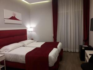 a hotel room with a large bed with a red headboard at Gea suite in Naples