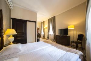 a hotel room with a bed and a television at Optima Collection Medievale Lviv in Lviv