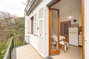 einen Balkon mit einer Tür zu einer Küche mit einem Tisch in der Unterkunft Il Giardino delle Ortensie in Salto