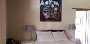 a bedroom with a bed and a painting on the wall at Disa Lodge in Darling