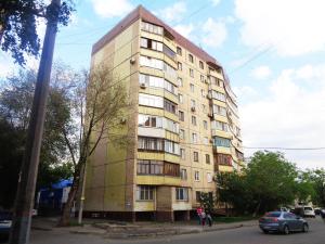 un grand bâtiment sur le côté d'une rue dans l'établissement Староярмаркова с видом на парк и реку, à Kryvy Rih