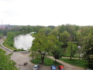 克里沃羅格的住宿－Староярмаркова с видом на парк и реку，享有河流美景,停车场内有车辆停放