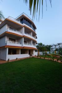 a building with a lawn in front of it at Tridiva Morjim 160 Meters to Morjim Beach in Morjim