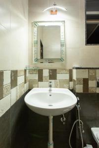 a white sink in a bathroom with a mirror at Tridiva Morjim 160 Meters to Morjim Beach in Morjim