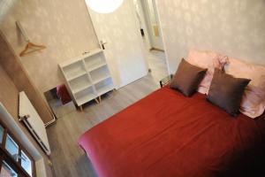 a bedroom with a bed with red sheets and pillows at Maison La Rive in Publier