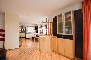 a kitchen with wooden cabinets and a living room at Ferienhaus MelBe in Seeboden