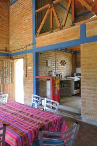 Il comprend une cuisine équipée d'une table, de chaises et d'un réfrigérateur. dans l'établissement Cabañas A la Maison, à Mina Clavero