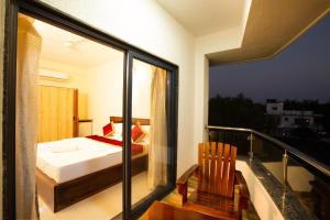 a bedroom with a bed and a balcony at Tridiva Morjim 160 Meters to Morjim Beach in Morjim